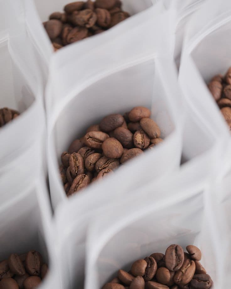 Bags of roasted coffee beans, open on the counter.